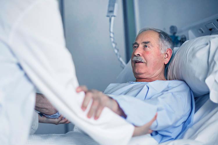 Un hombre acostado en una cama de hospital